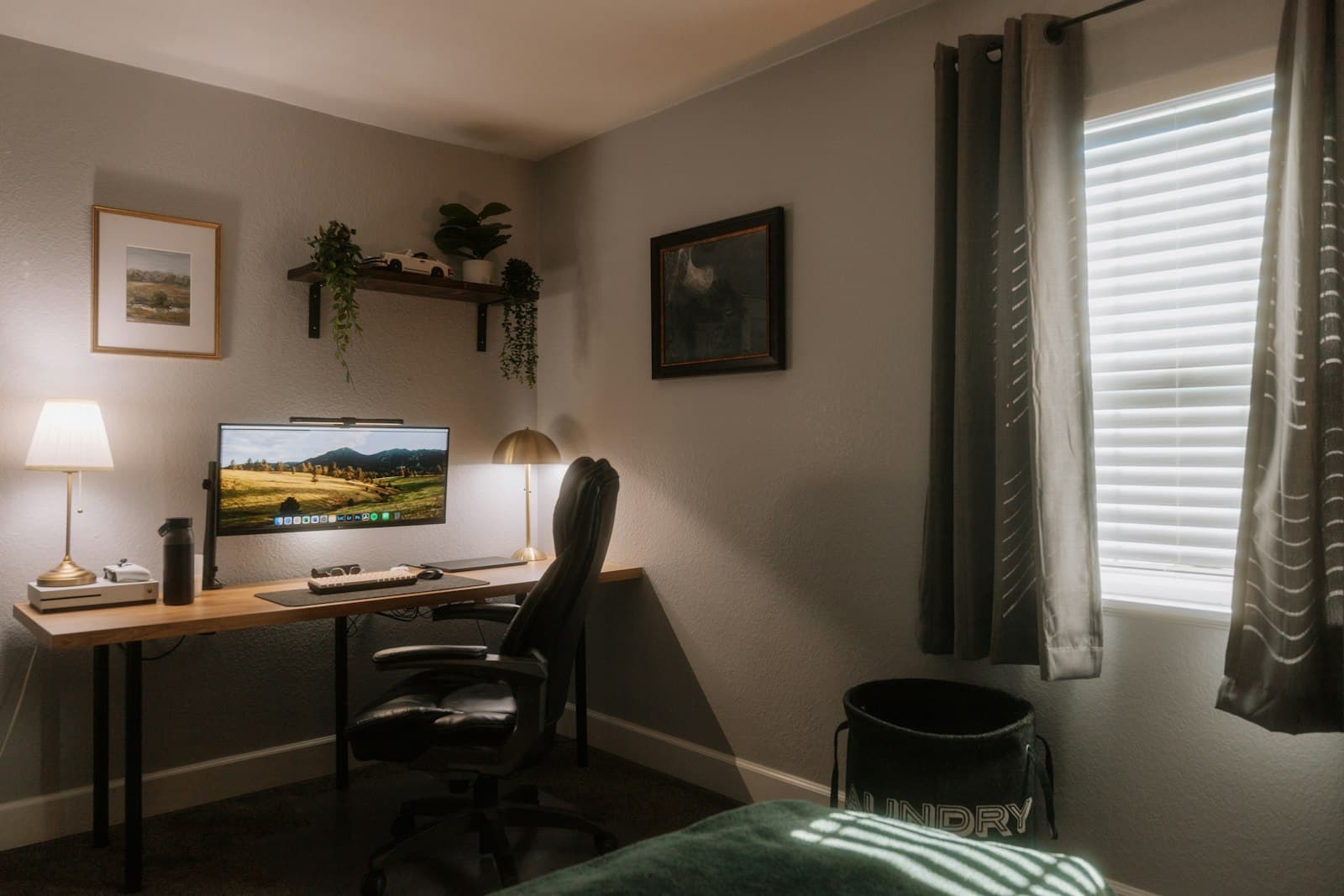 A calm home office corner with a wooden desk, task lighting and a warm bedside lamp.