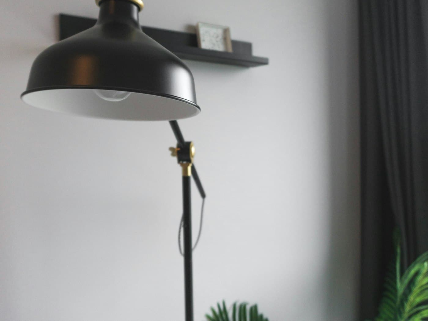A black adjustable task lamp glowing warmly, illustrating focused, adjustable light positioned near a work surface.